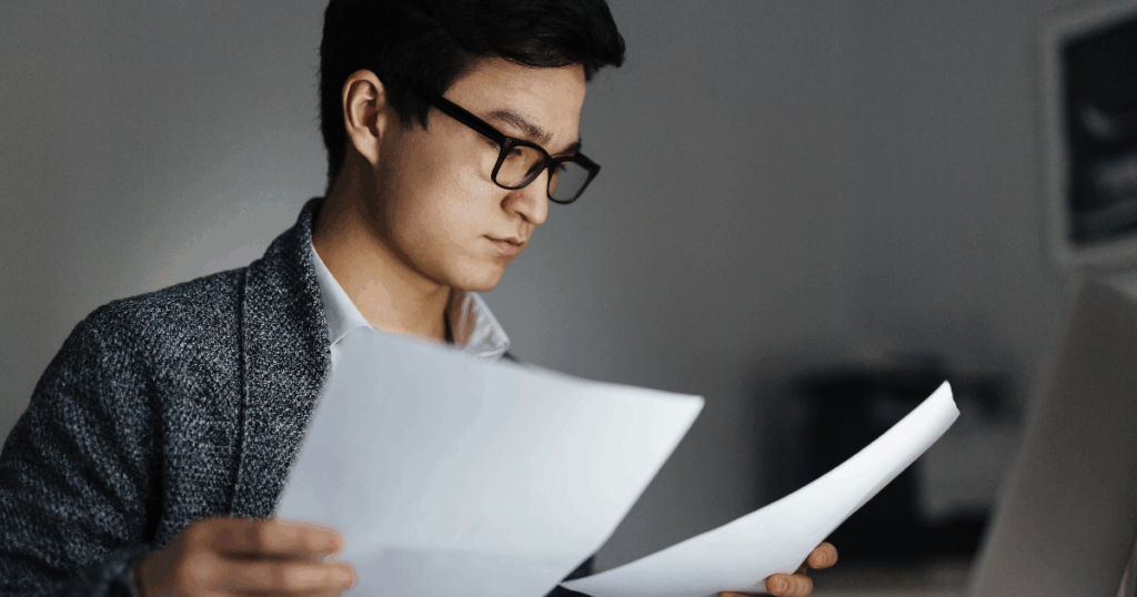 Male nurse reading paperwork from the Texas BON.