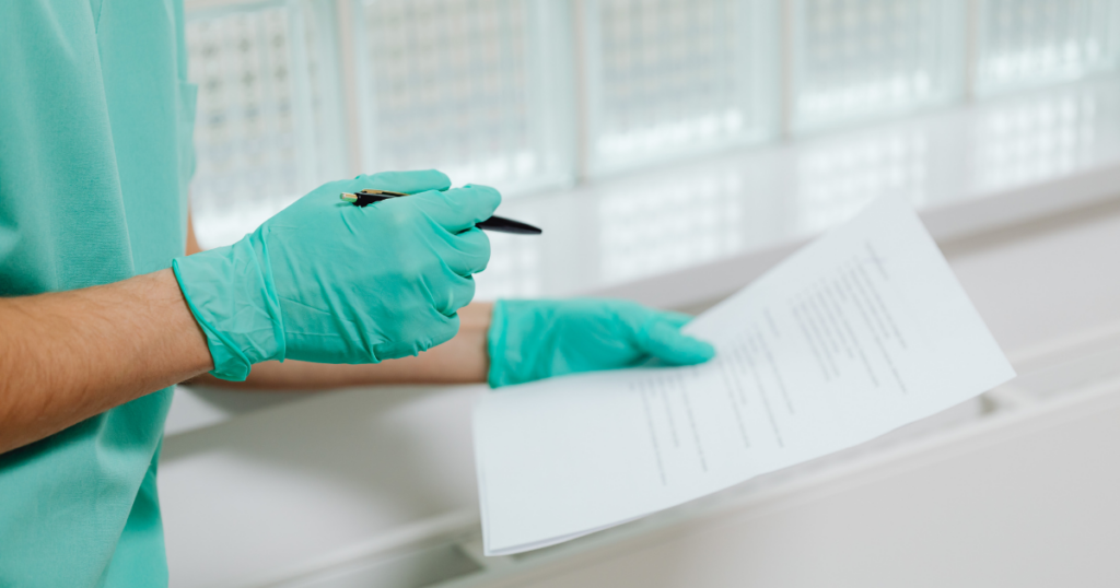 Nurse in green scrubs and green gloves is looking over their response to the Texas BON Notice of Allegations they received. 