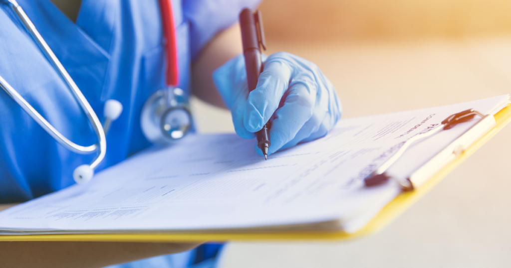 Nurse in blue scrubs and blue gloves signing and looking over their California BRN Letter of Accusation.