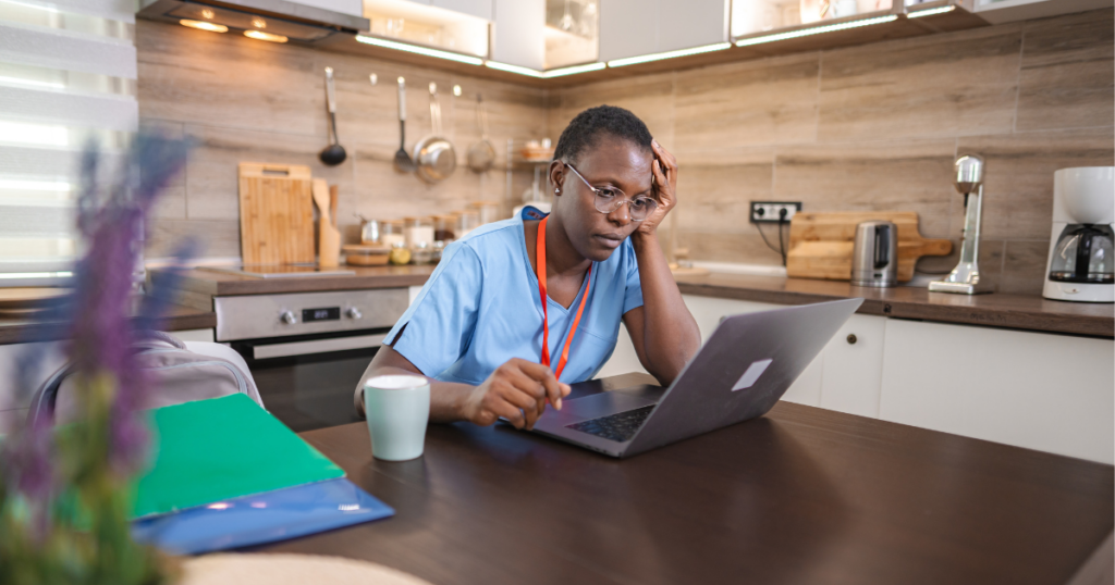 Nurse facing criminal charges on her laptop looking for legal defense strategies.