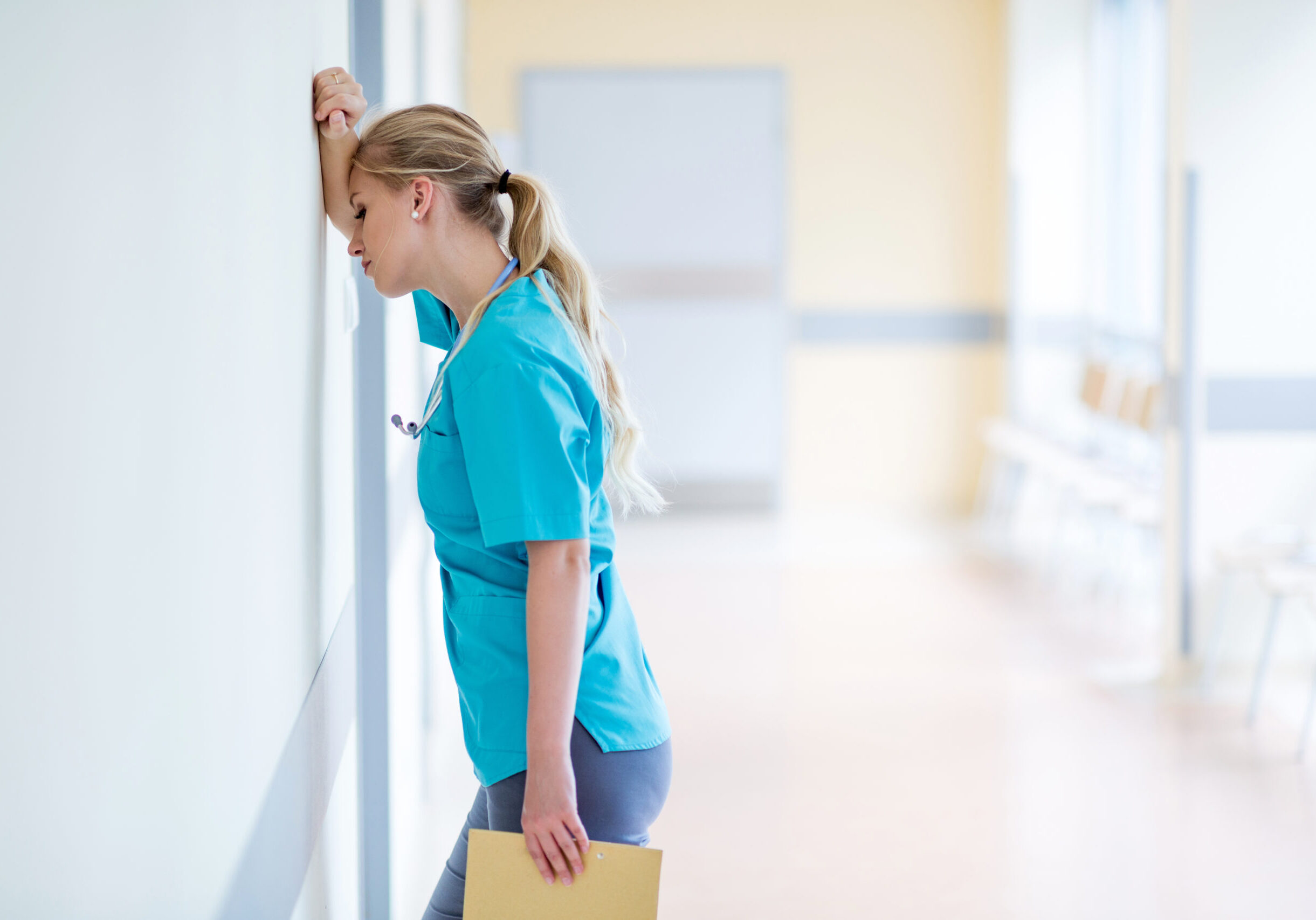 Tired female nurse in hospital corridor